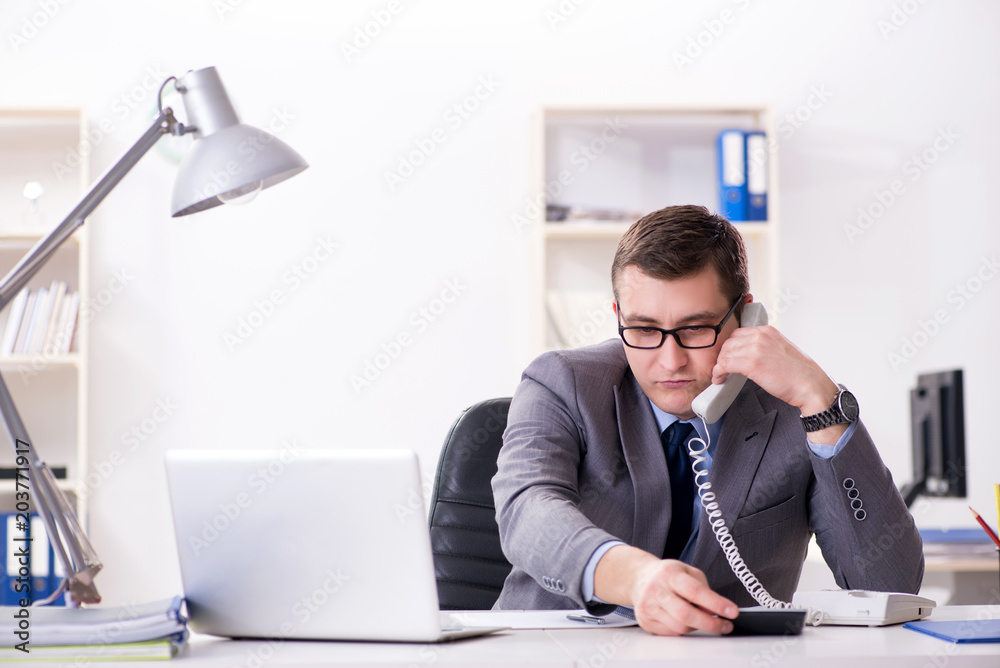 Businessman employee talking on the office phone Businessman employee talking on the office phone