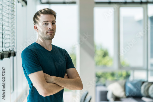 casual handsome caucasian man standing with blue office background © whyframeshot
