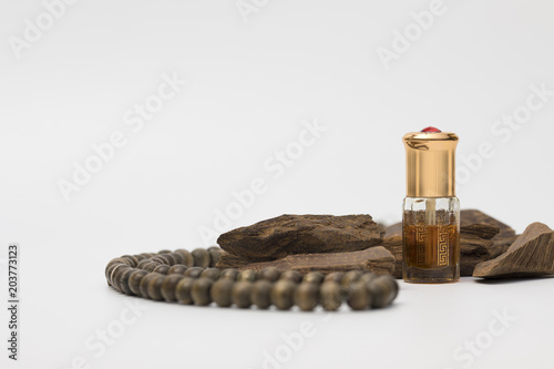 Bottle of oil agarwood perfume with Incense Chips isolated on white background