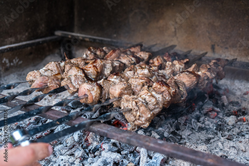 Georgian mtsvadi (Shashlik) preparation. Smoking shashlik on the grill. BBQ on Stick