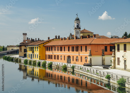 Cityscape of Gaggiano, just outside of Milan. Colourful houses reflected in the Naviglio Grande canal waterway photo