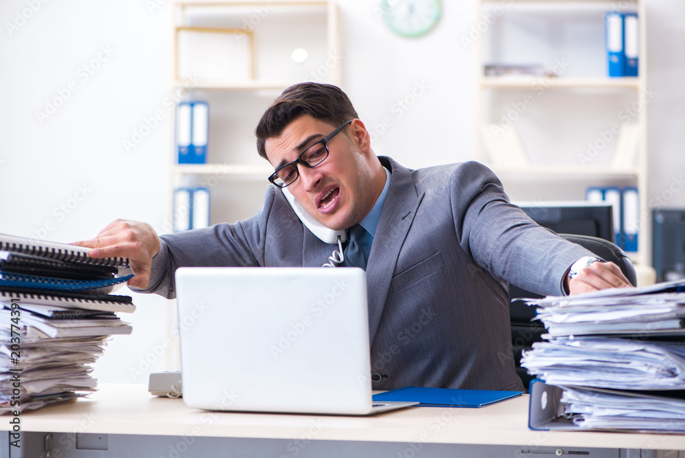 Desperate sad employee tired at his desk in call center Desperate sad employee tired at his desk in call center