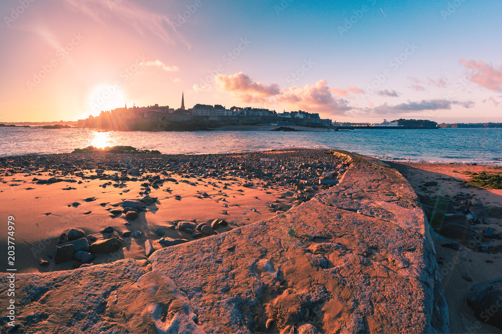 View from the tidal island of Grand Be to the city of Saint Malo and flooded path causeway at high tide at sunrise. Saint-Malo is famous city of Privateers is known as city corsaire, Brittany, France. - obrazy, fototapety, plakaty 
