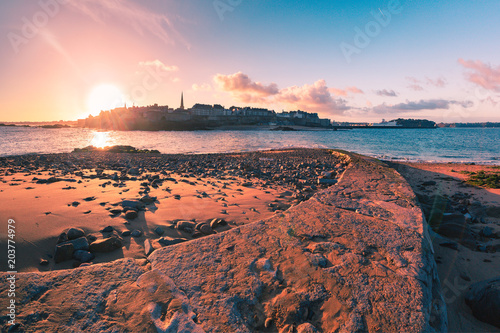 View from the tidal island of Grand Be to the city of Saint Malo and flooded path causeway at high tide at sunrise. Saint-Malo is famous city of Privateers is known as city corsaire, Brittany, France.