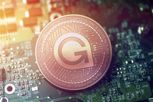 shiny copper GAMECREDITS cryptocurrency coin on blurry motherboard background photo