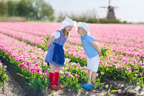 Kids in tulip flower field. Windmill in Holland #203780781