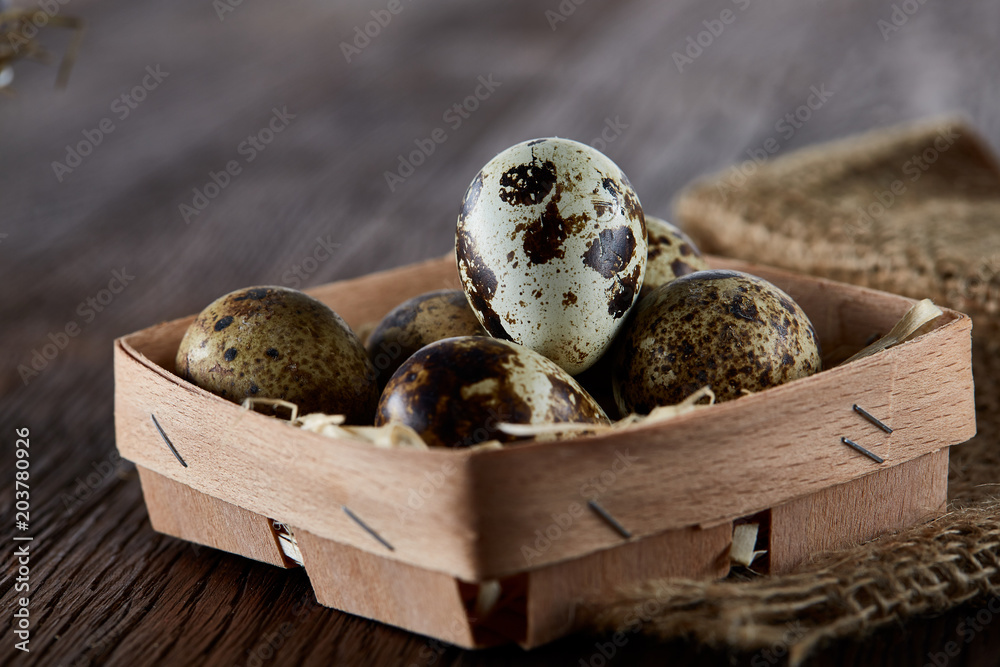 Rustic still life with quail eggs in bucket, box and bowl on a linen napkin over wooden background, selective focus Rustic still life with quail eggs in bucket, box and bowl on a linen napkin over wooden background, selective focus