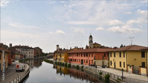 Cityscape of Gaggiano, just outside of Milan, Italy. Colourful houses reflected in the Naviglio Grande canal waterway. photo