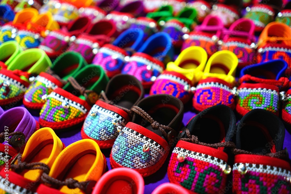 Rows of colorful hand made baby shoes in market