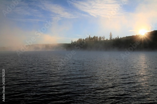 magische Sonnenstrahlen am See mit Nebel