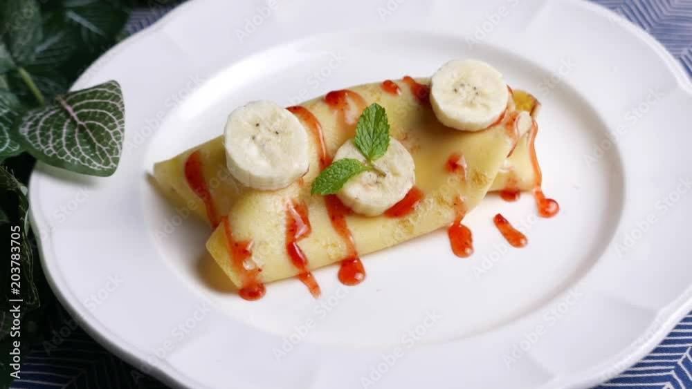 sweet crepe filled with banana set on dinner table. sweet crepe filled with banana set on dinner table.