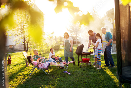 It was a beautiful sunny day when big family gathered on a picnic in a field.