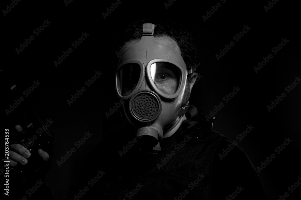man armed with gun and gas mask on dark background man armed with gun and gas mask on dark background