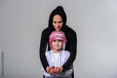 Young arabic boy together with his mom holding young plant in the hands. © manowar1973