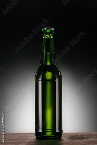 close up view of bottle of beer on dark grey backdrop