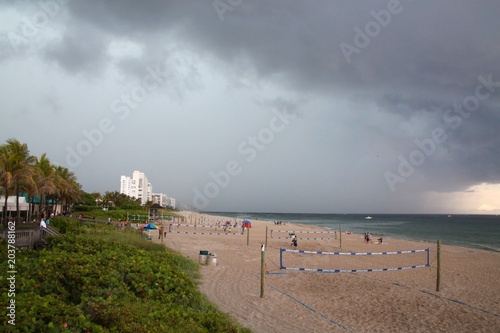 Heavy Thunderstorm Approaching over Condos from the North Toward Deerfield Beach, Florida with People Enjoying Recreation in the Sand Below