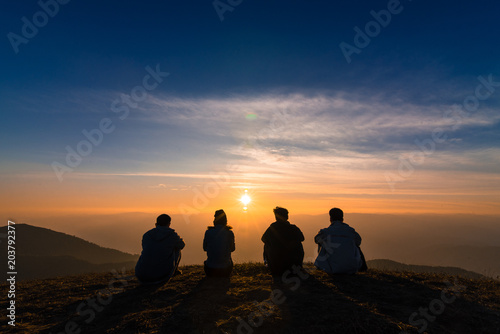 Fototapeta Naklejka Na Ścianę i Meble -  silhouette of friends  sitting together watching sunset for business successful and team work concept