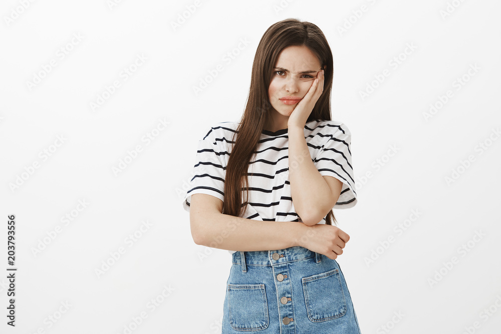 Feeling insult, puffling out cheeks from jealousy. Upset offended attractive caucasian woman, holding palm on cheek, frowning, being disappointed when boyfriend forbid go party with girlfriends Feeling insult, puffling out cheeks from jealousy. Upset offended attractive caucasian woman, holding palm on cheek, frowning, being disappointed when boyfriend forbid go party with girlfriends