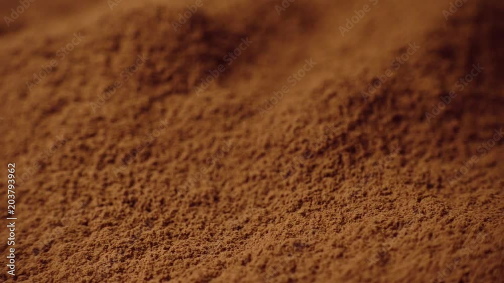 Shot of cocoa powder being sifted through a small handheld sift and rotating, close-up, 4K Shot of cocoa powder being sifted through a small handheld sift and rotating, close-up, 4K