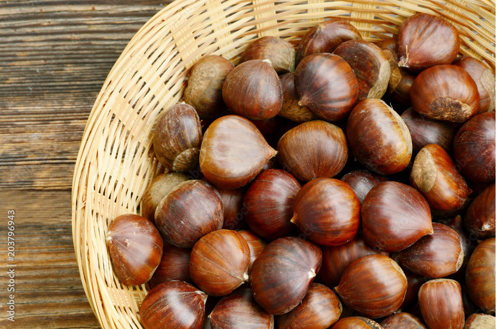 Castanea sativa or sweet chestnut in the basket on wooden background. Castanea sativa or sweet chestnut in the basket on wooden background.