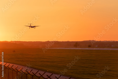 Passenger plane approaching at Lech Walesa Airport in Gdansk at sunset time. photo