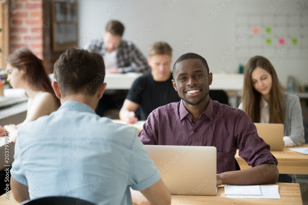 Happy african american worker smiling looking at camera satisfied with company market success, high income and good results. Excited black student pleased with work evaluation. Education, outsourcing Happy african american worker smiling looking at camera satisfied with company market success, high income and good results. Excited black student pleased with work evaluation. Education, outsourcing