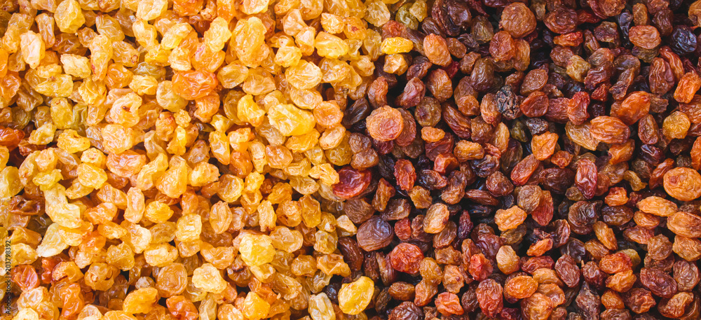Raisins from white and black grapes forming a multi colored abstract texture background Raisins from white and black grapes forming a multi colored abstract texture background