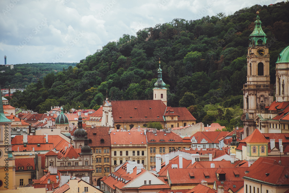 view on the red roofs and church of old European city. Prague