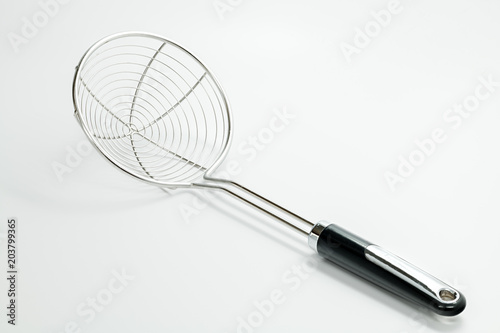 Metal strainer with a plastic handle used in cooking in the kitchen