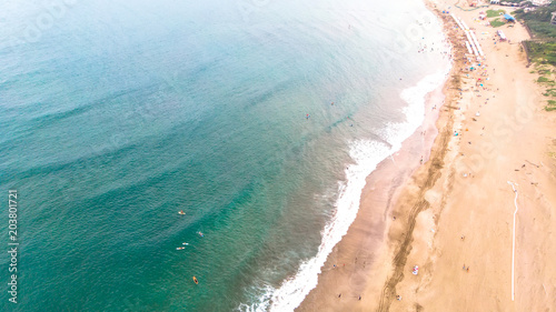 "Aerial view of sandy beach with tourists swimming in beautiful clear sea water"