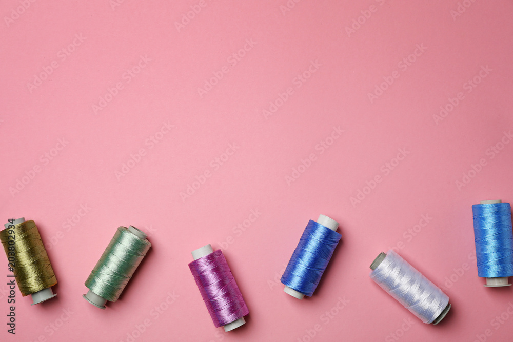 Fototapeta premium Flat lay composition with sewing threads on color background