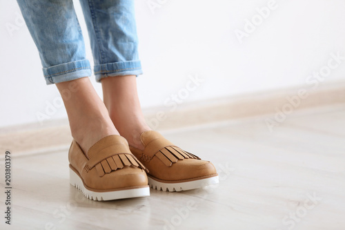 Young woman wearing elegant shoes indoors, closeup