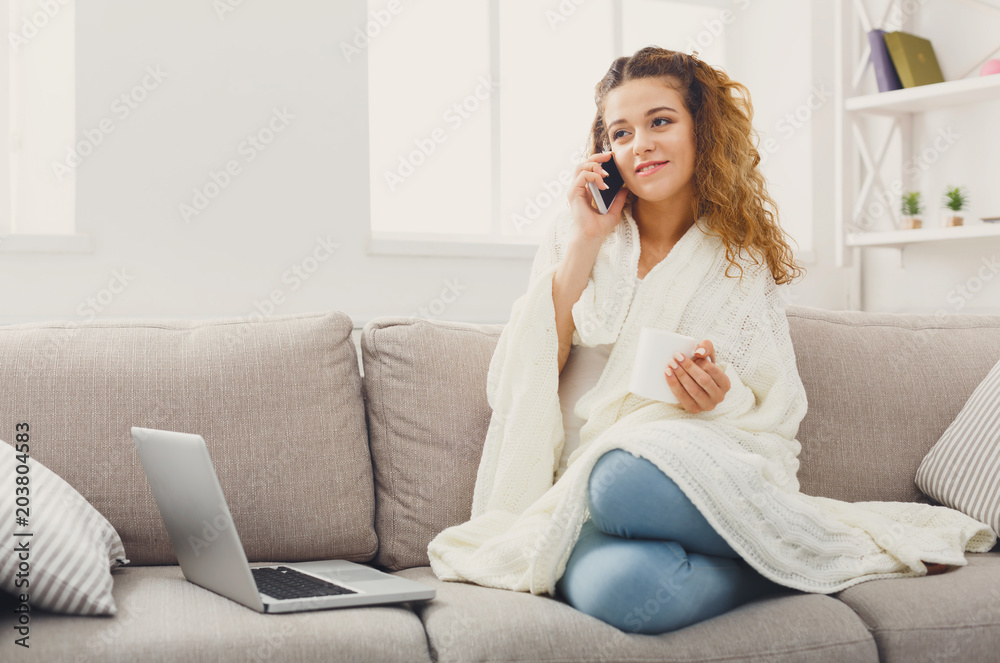 Cozy home. Girl in blanket with mobile Cozy home. Girl in blanket with mobile