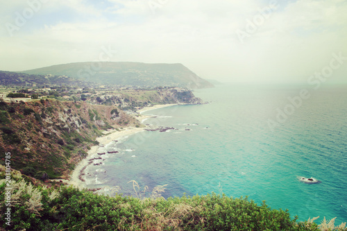 Landscape view from cliff Capo Vaticano, beautiful nature in Calabria, Italy. Seashore, beach and turquoise sea with hills and green trees and plants.