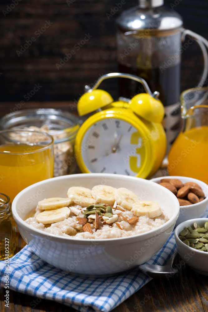 oatmeal with banana, honey and nuts for breakfast, vertical