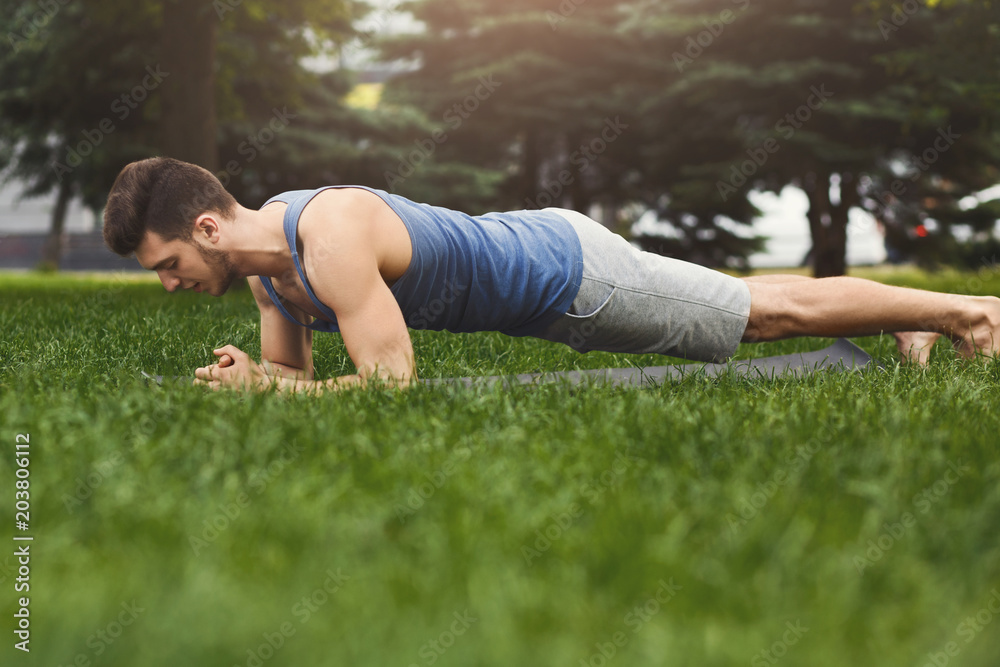 Fitness man plank training in park outdoors Fitness man plank training in park outdoors