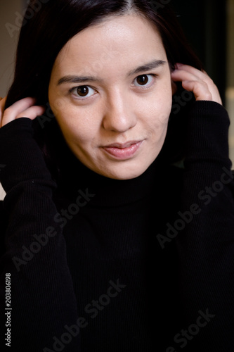 Indoor portrait of young beautiful model of mixed race dressed in black