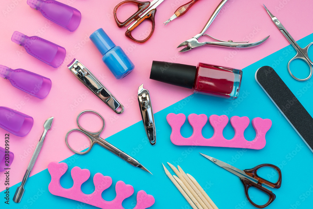 Manicure or pedicure tools scattered on a pink and blue background. Manicure or pedicure tools scattered on a pink and blue background.