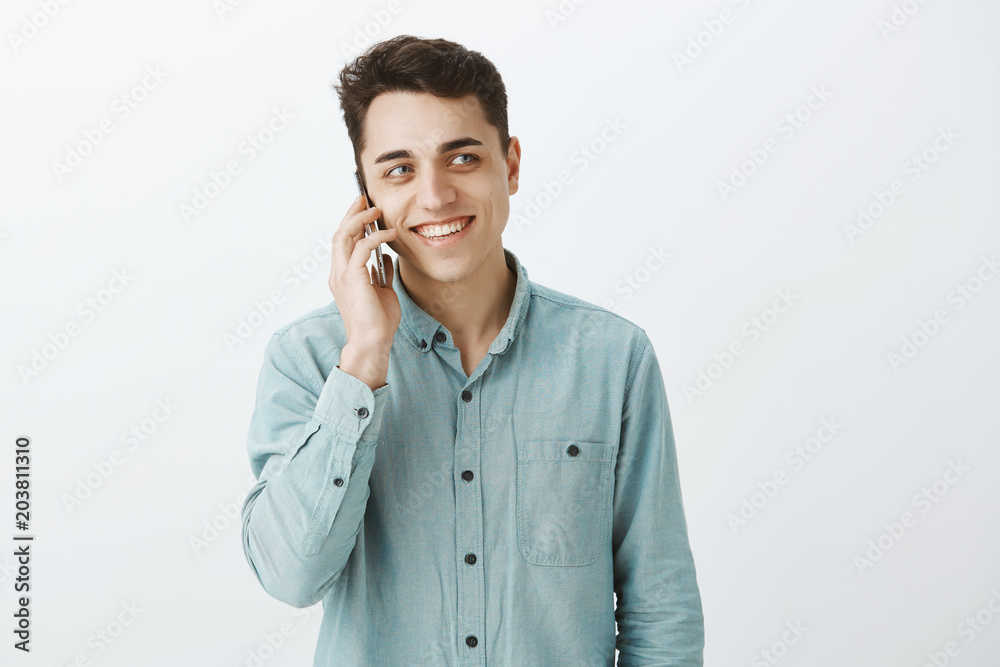 Friendly-looking confident caucasian guy in shirt, talking on smartphone and looking right with cheerful smile, talking with girlfriend or friend, retelling funny moment from office meeting Friendly-looking confident caucasian guy in shirt, talking on smartphone and looking right with cheerful smile, talking with girlfriend or friend, retelling funny moment from office meeting