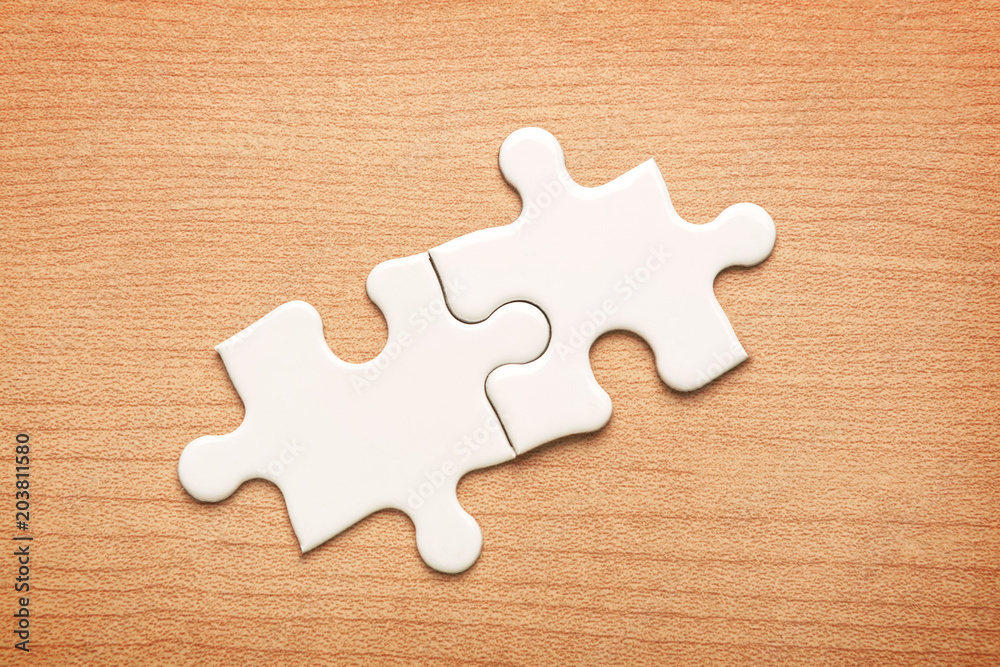 Fototapeta premium White jigsaw puzzle on wood background