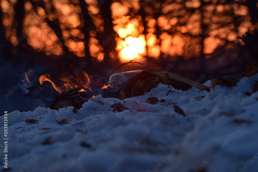 Un beau deu de camp sur neige devant le couché de soleil, rien de mieux pour préparer le diner Un beau deu de camp sur neige devant le couché de soleil, rien de mieux pour préparer le diner