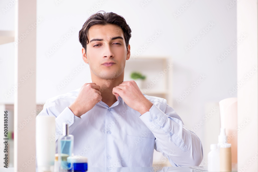 Man is getting dressed up for work in bathroom Man is getting dressed up for work in bathroom