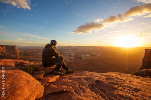 Hiker meets sunset at Grand view point in Canyonlands National park in Utah, USA