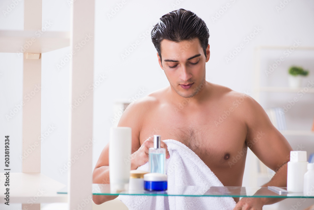 Young man is getting prepared for working day in bathroom Young man is getting prepared for working day in bathroom