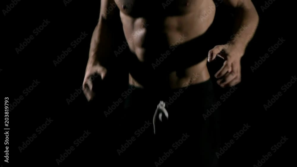 Slow motion of man shadow boxing in black background. Young white man with six packs.. Fighting sprit concept. Slow motion of man shadow boxing in black background. Young white man with six packs.. Fighting sprit concept.