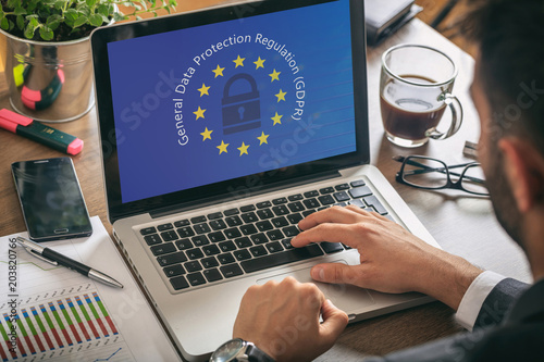 Man working with a computer, General Data Protection Regulation and European Union flag on the screen photo