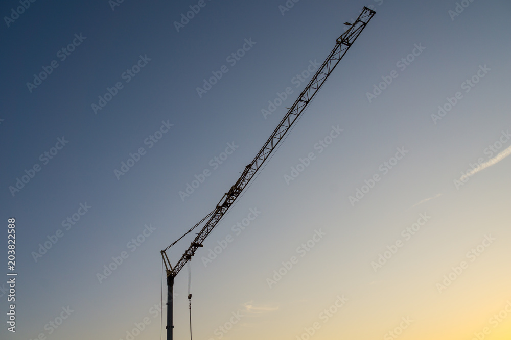 Germany, Huge crane in sunset light at end of day building new houses Germany, Huge crane in sunset light at end of day building new houses