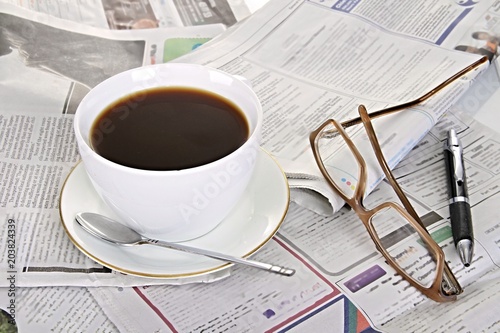 hot cup of black coffee on the table with newspaper