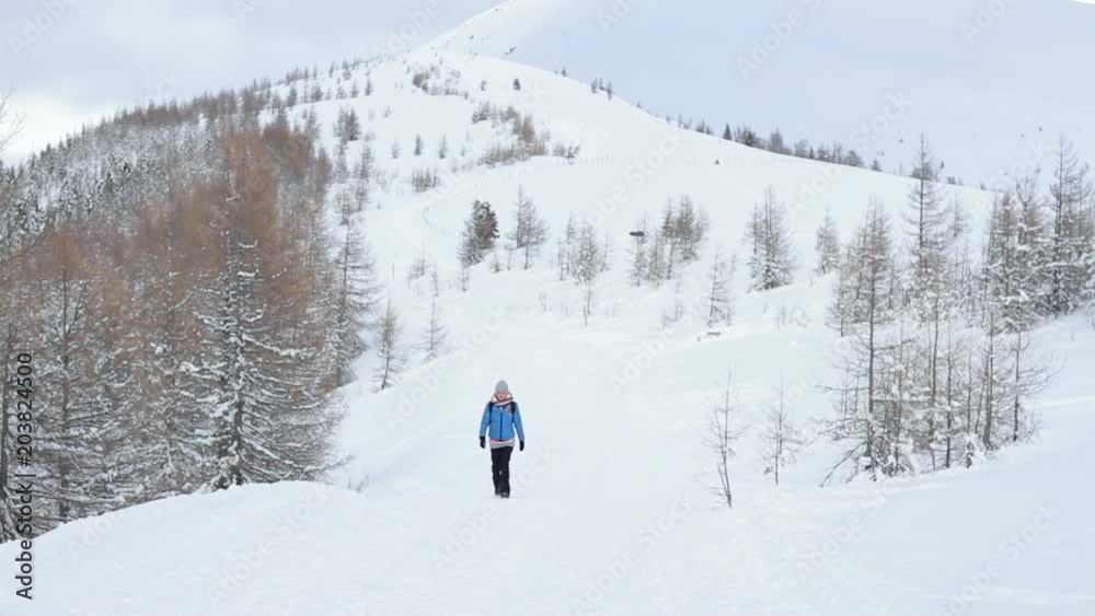 Woman walking in the snowy mountains and looking at beautiful view, Alps, Austria Woman walking in the snowy mountains and looking at beautiful view, Alps, Austria