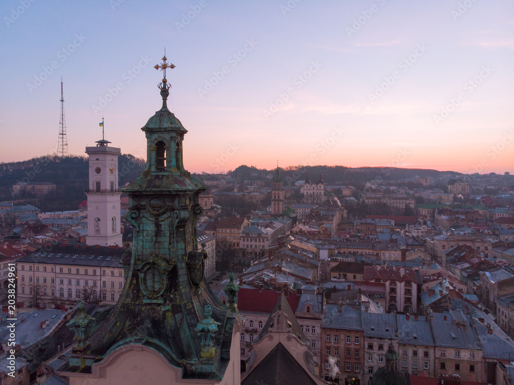 old church tower with sunrise on background. european cityscape aerial view